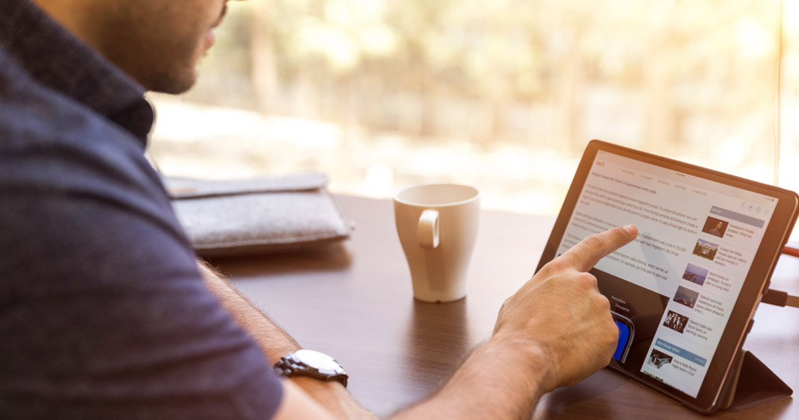 Leaptel - man at desk browsing iPad